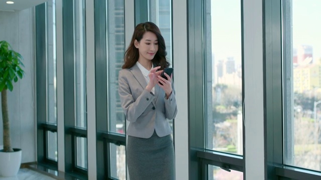 年轻商务女士使用手机视频下载