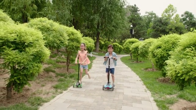 儿童在公园里玩滑板车视频素材