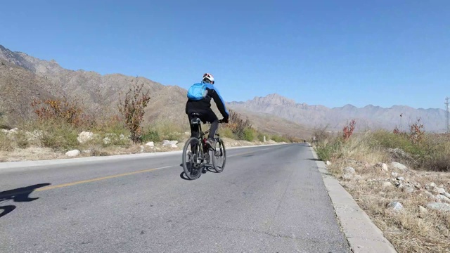 在宁夏贺兰山边沿山公路骑行健身的自行车人员视频下载