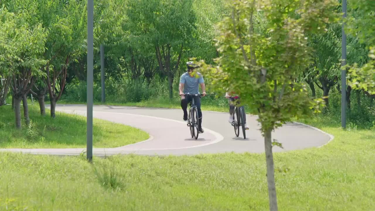 开心的中老年夫妇在公园骑自行车视频下载