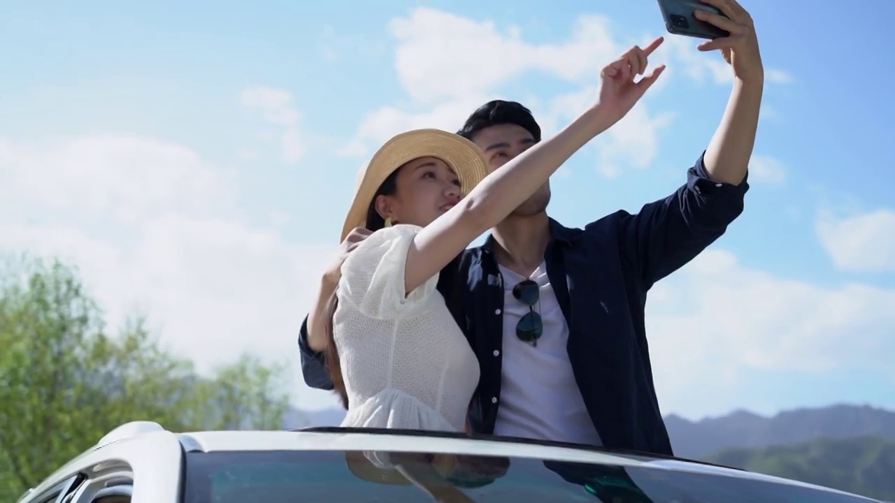 青年夫妻在汽车上用手机拍照视频下载