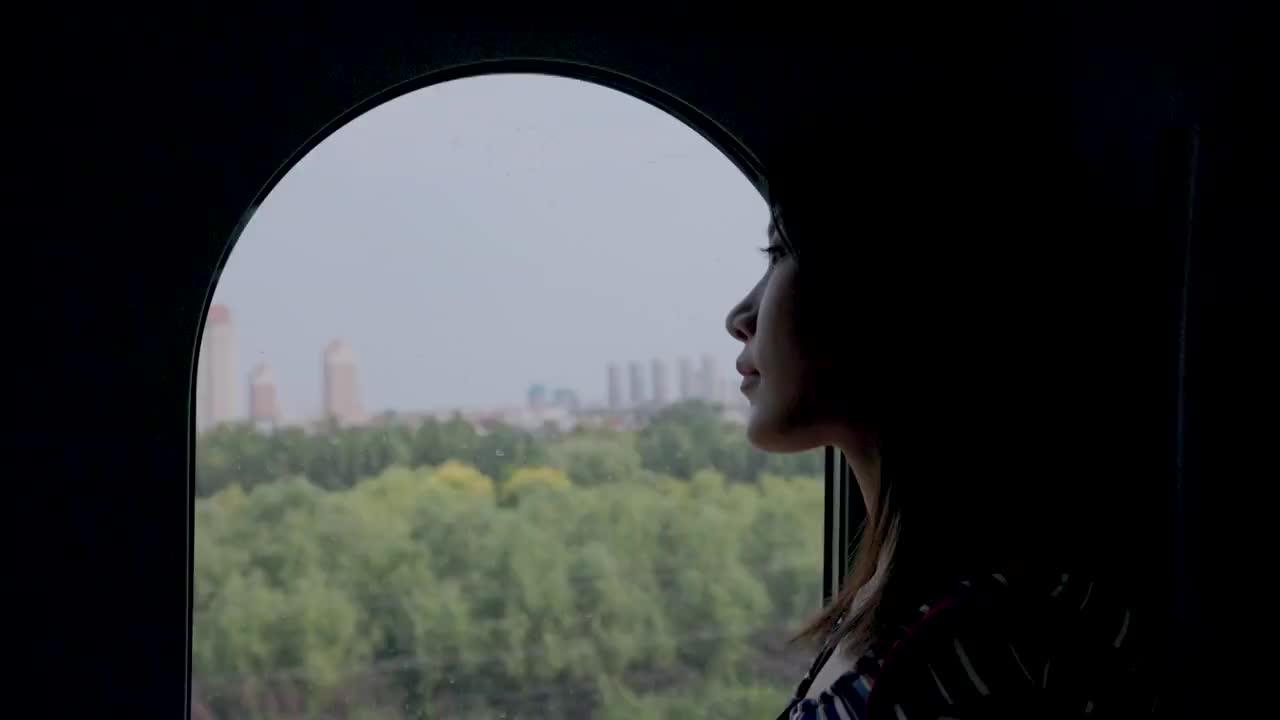 車廂內站在車窗旁看風景的青年女人視頻素材