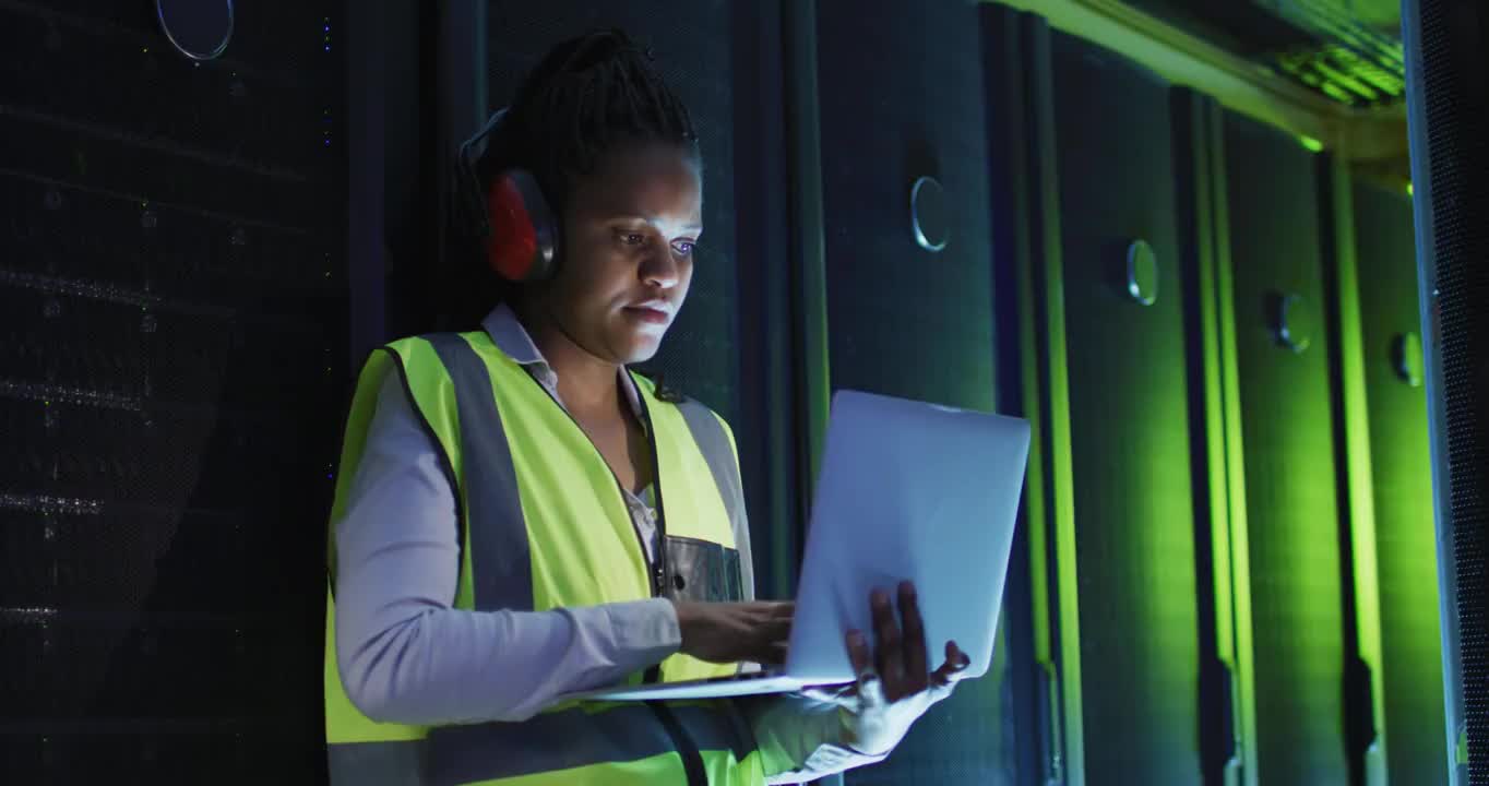 非裔美国女性计算机技术人员使用笔记本电脑在企业服务器室工作视频购买