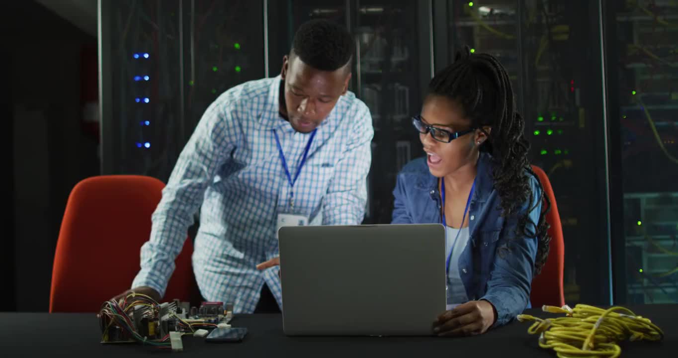 非裔美国计算机技术人员使用笔记本电脑在业务服务器室工作视频购买