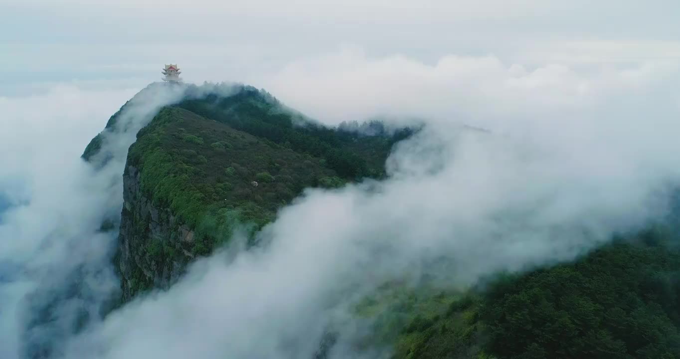 四川峨眉山萬佛頂金頂空中風景山頂上的寺廟高聳，四周云霧繚繞，薄霧在山上的森林中快速流動視頻素材