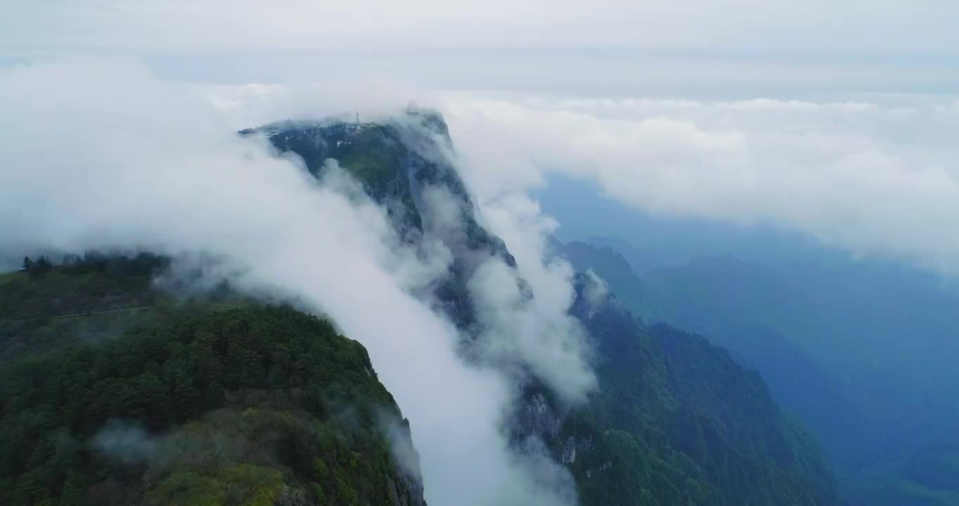 四川峨眉山萬佛頂金頂空中風景山頂上的寺廟高聳，四周云霧繚繞，薄霧在山上的森林中快速流動視頻素材