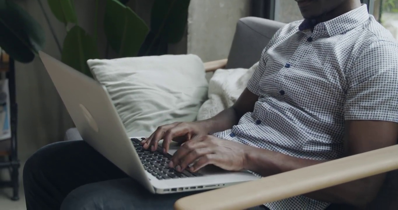 一个黑人在办公室里使用笔记本电脑的特写侧视图非洲男人研究思考视频素材