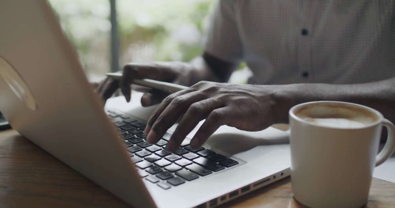 一个黑人在办公室里使用笔记本电脑的特写非洲男人在门上打字在电视频素材