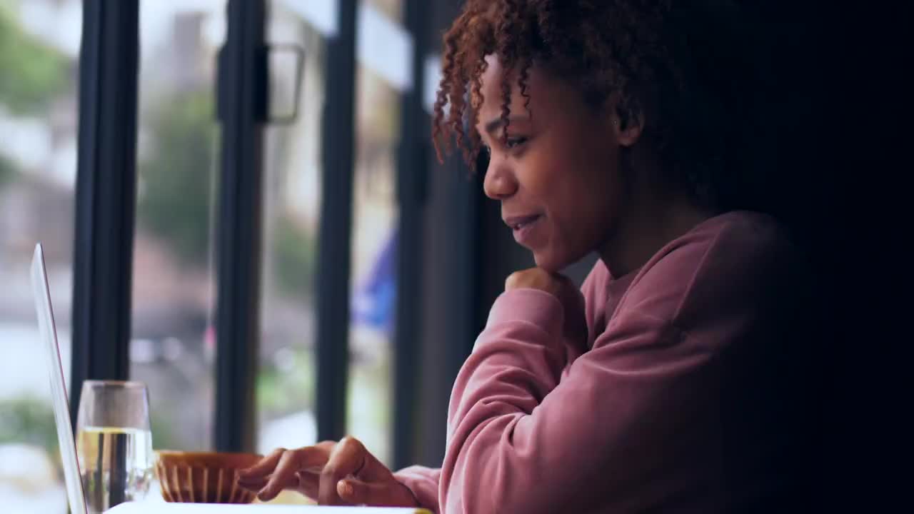 一个黑人女生坐在窗边工作视频素材