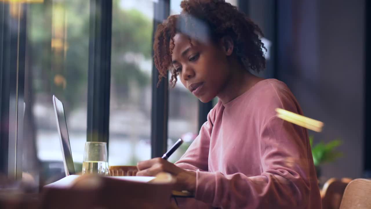 一个黑人女生坐在窗户边写作视频素材
