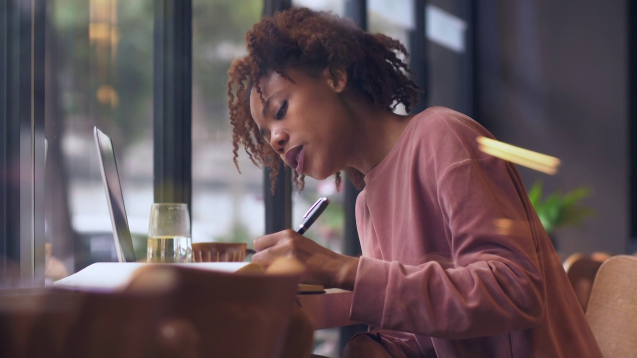 一个黑人女生坐在窗边写作视频素材