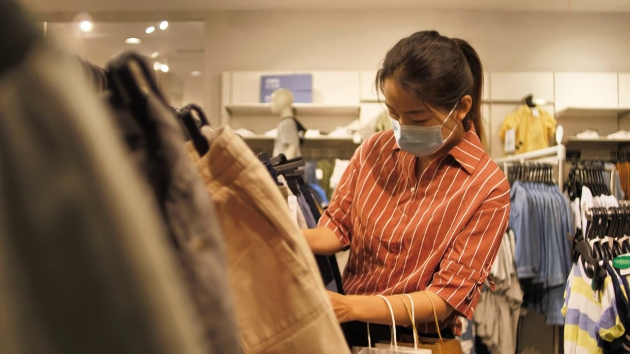 亞洲東方中國女性在商場內挑選衣服購物視頻下載