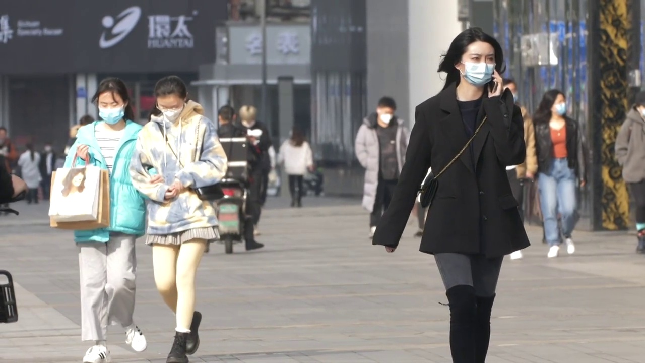 女人戴着口罩在街头打电话慢镜头视频素材