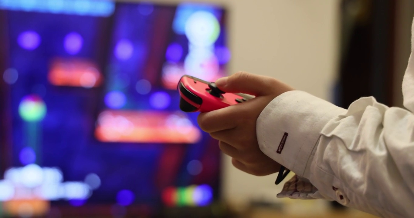 游戏娱乐：小孩使用无线体感手柄玩电视游戏视频素材
