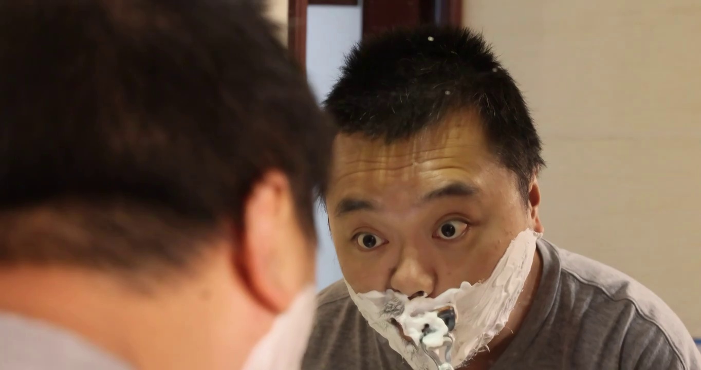 人像日常清洁：油腻的男人使用剃须刀刮掉了胡子视频下载
