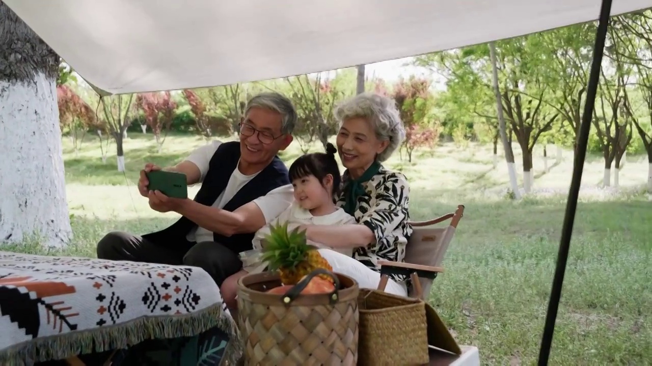 爷爷奶奶和孙女在公园露营玩耍视频素材