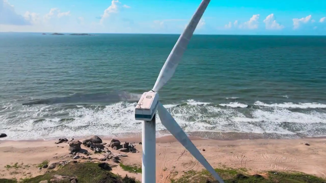 海边沙滩上的风力发电风车视频素材