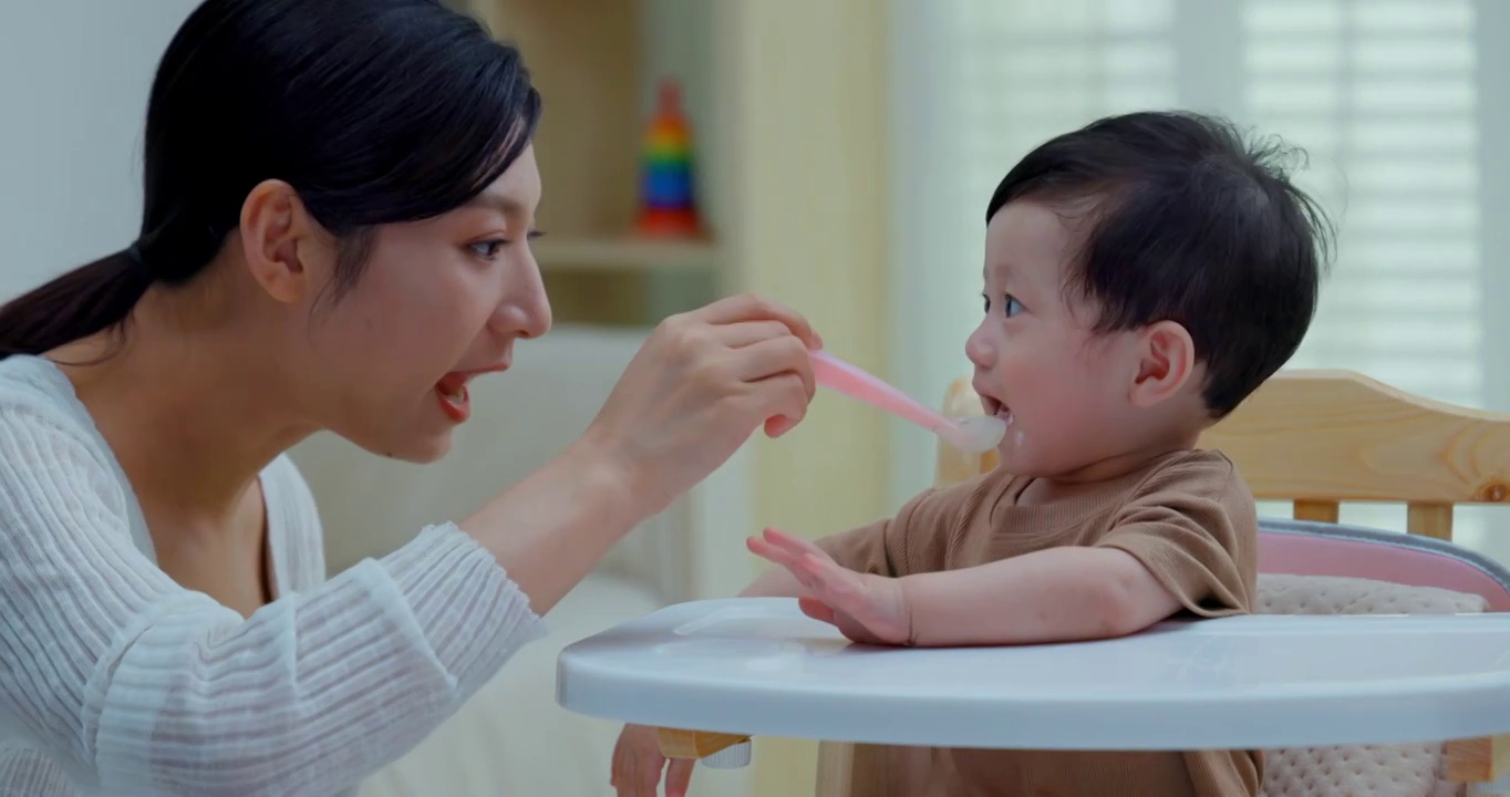 年輕媽媽喂寶寶吃飯視頻素材