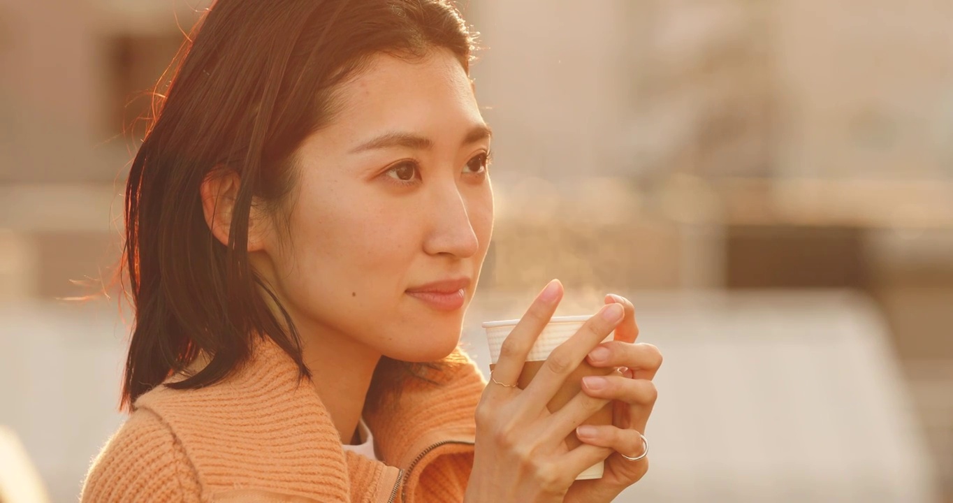 年輕的日本女人在外面喝咖啡視頻素材