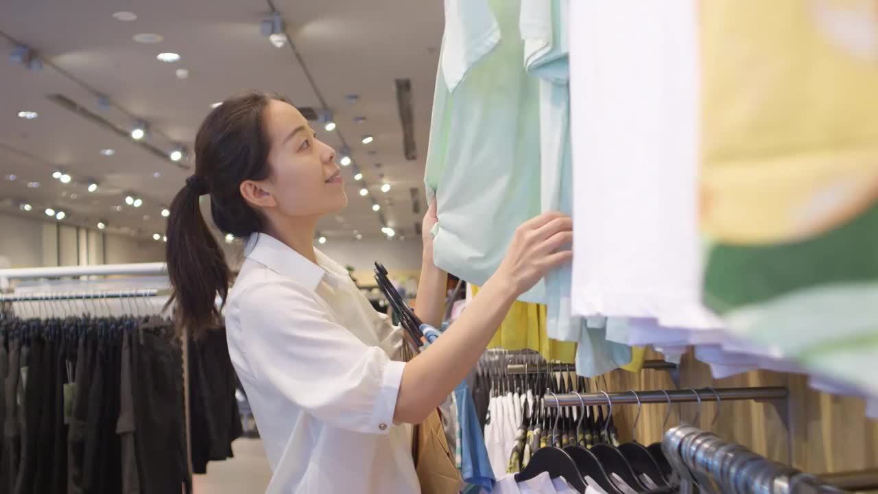 亞洲東方中國女性在商場內挑選衣服購物視頻下載