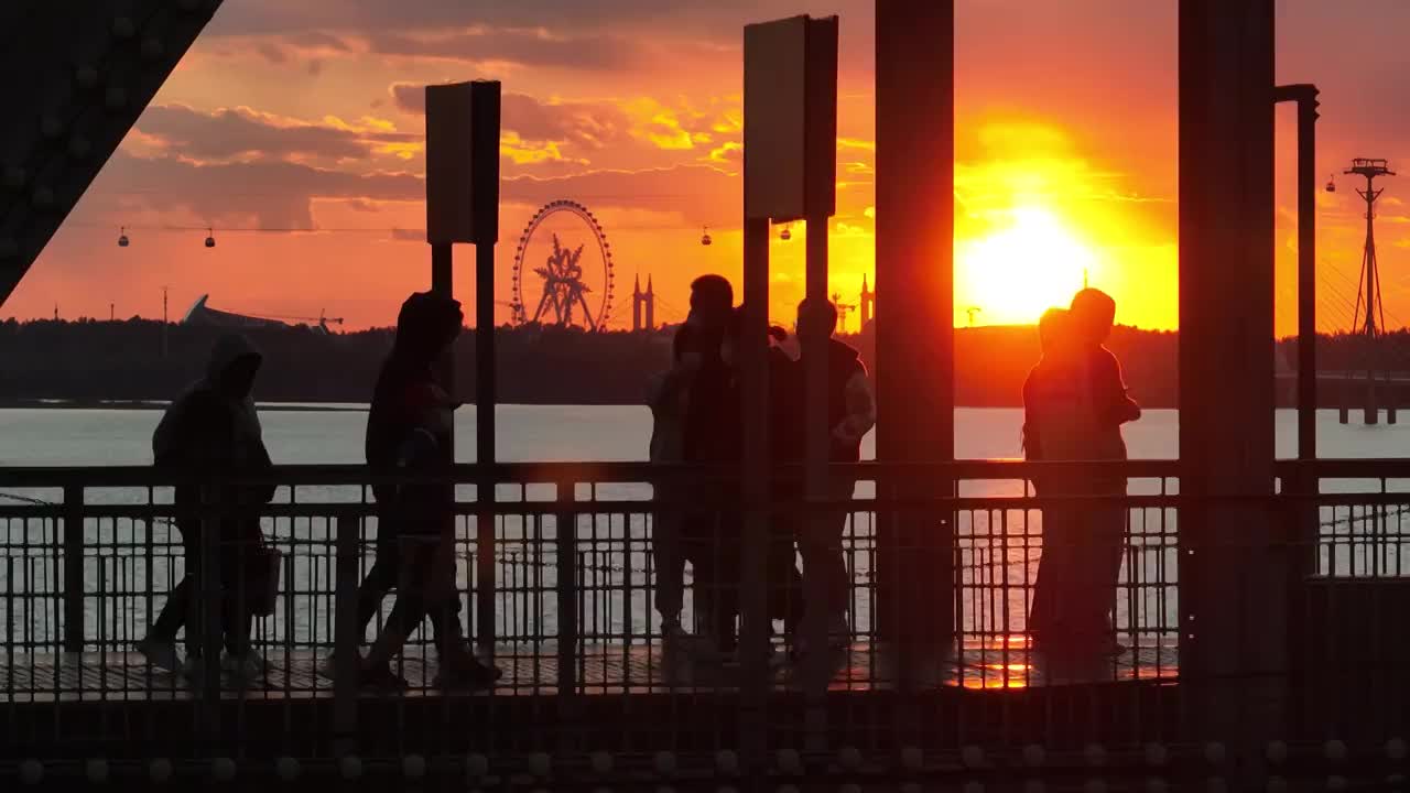 4K哈爾濱鐵路橋欄桿黃昏日落人物剪影慢動作航拍視頻素材