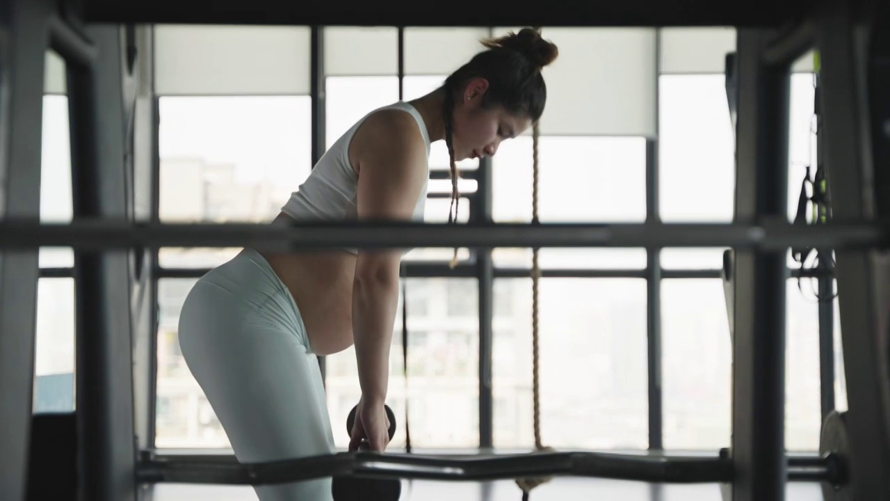 现代女性怀孕的妇女在健身房锻炼身体撸铁视频素材