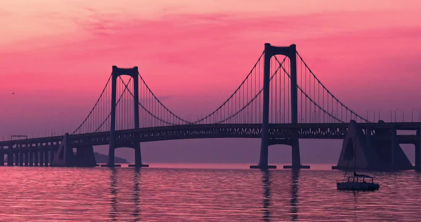 星海湾大桥，日出时星海湾大桥的天空，清晨桥梁的朝霞，跨海大桥的日出视频下载