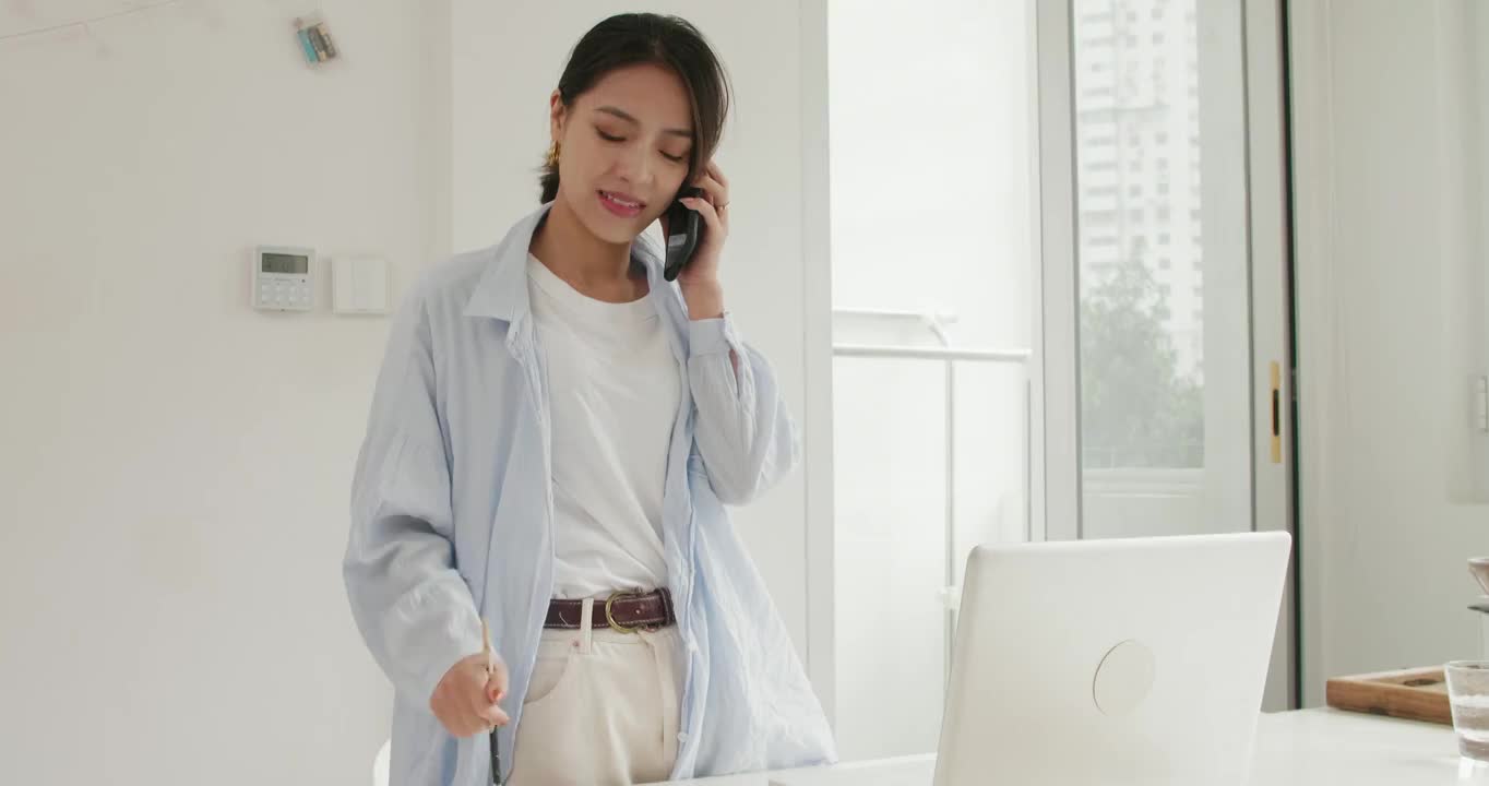 美丽中国女青年居家办公用手机打电话看电脑视频素材