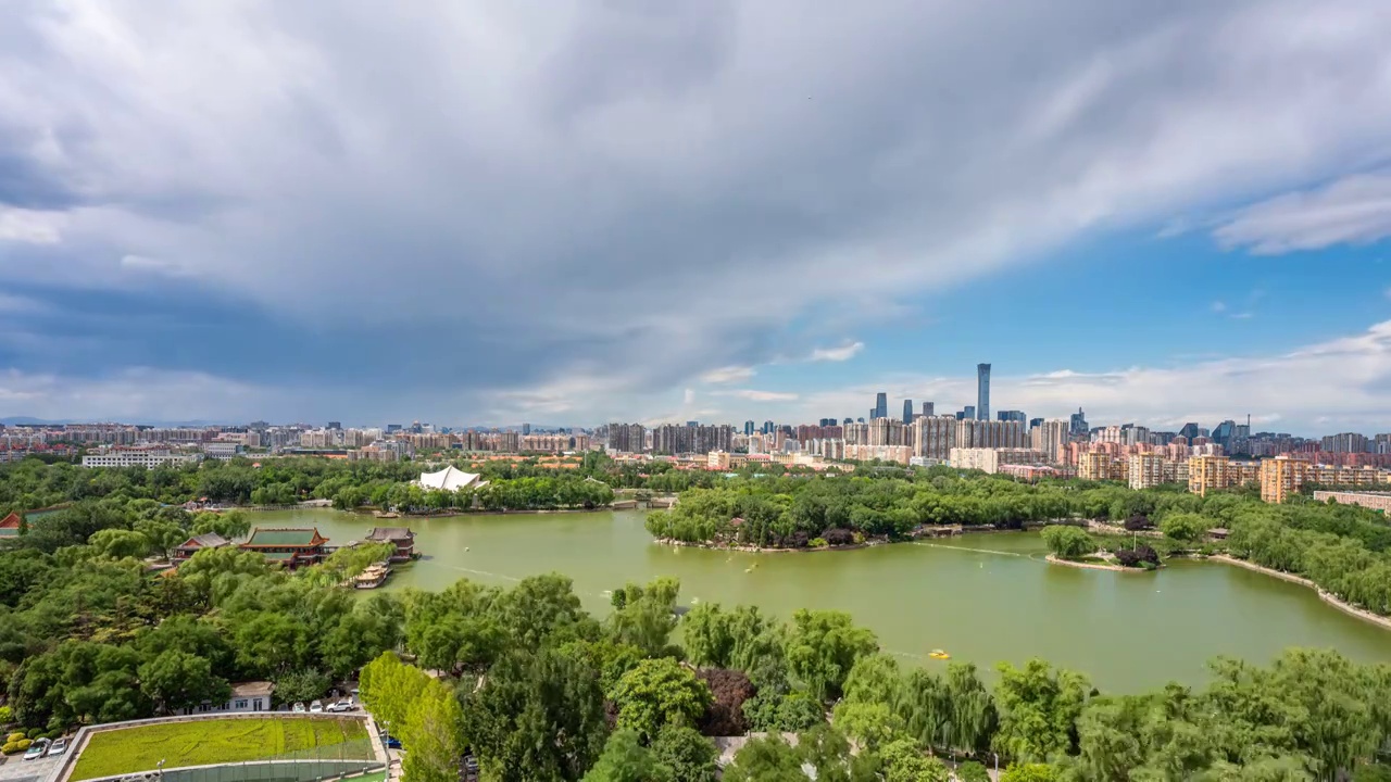 俯瞰北京龙潭湖公园绿树碧水和远处国贸中国尊城市天际线风光（8K）视频素材