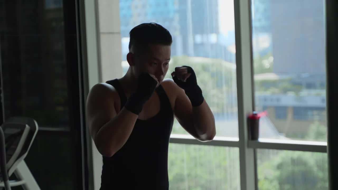年轻男人在健身房锻炼身体练习拳击视频下载