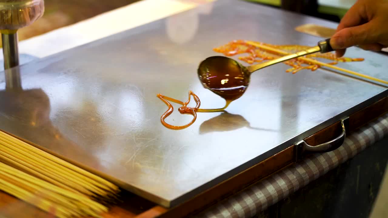 南京夫子庙老门东，民间传统非遗手工糖画，画兔子的图案视频素材