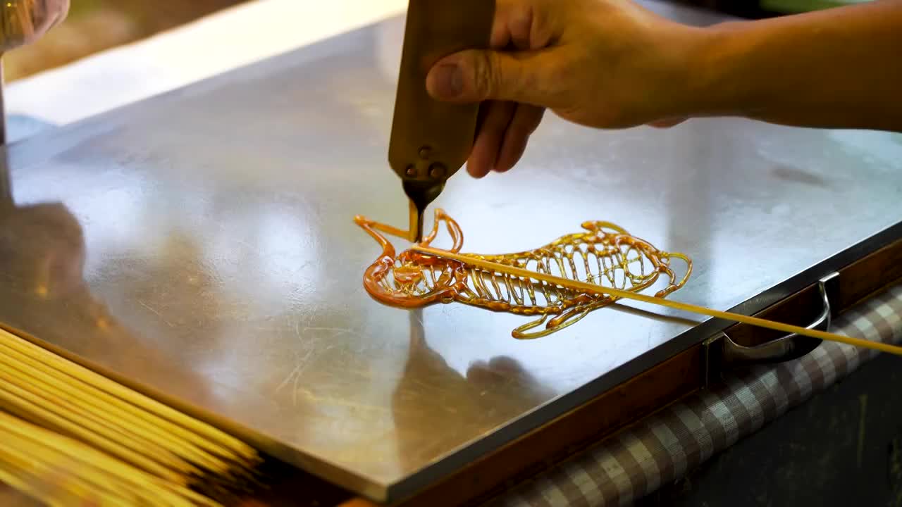 南京夫子庙老门东，民间传统非遗手工糖画，制作兔子图案糖画视频素材