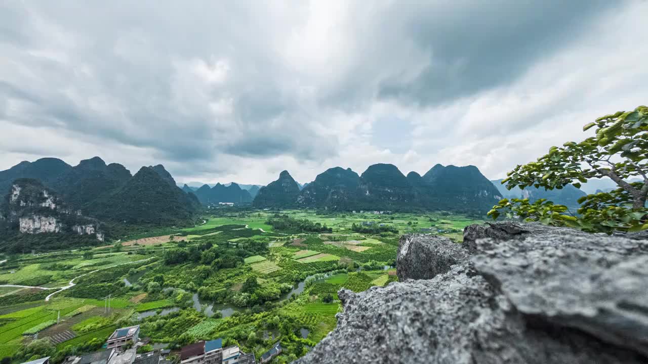 蓝天白云下在山顶上俯瞰桂林喀斯特山峰间的村庄和稻田视频下载