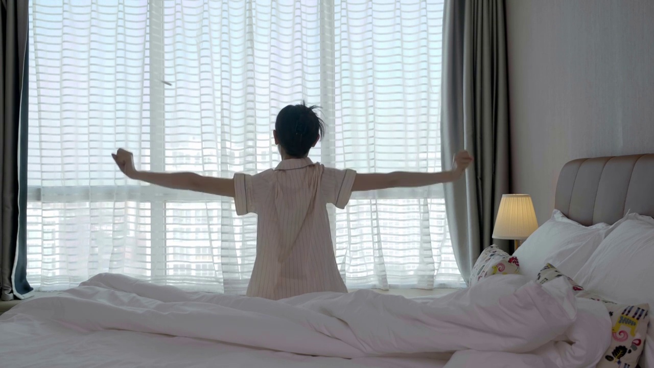 年轻的亚洲女性起床伸懒腰视频素材