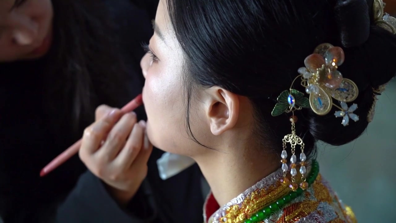 接亲婚礼现场新娘化妆师跟妆在给身穿绣荷衣新娘补妆中国女人视频下载