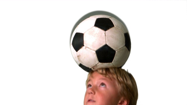 白色背景下的慢镜头里，小男孩顶着足球视频下载