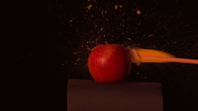 箭射穿过红苹果在黑色背景的慢动作视频下载