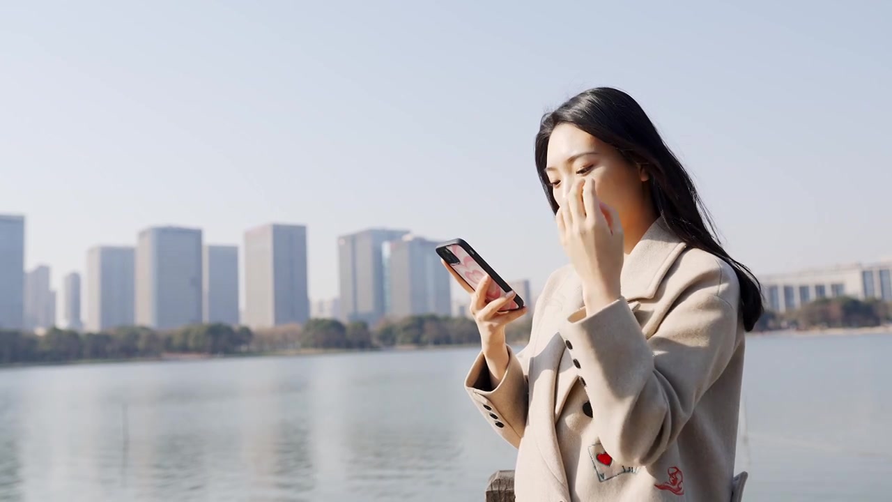 年轻都市女性无锡尚贤湖边拨弄头发玩手机视频下载