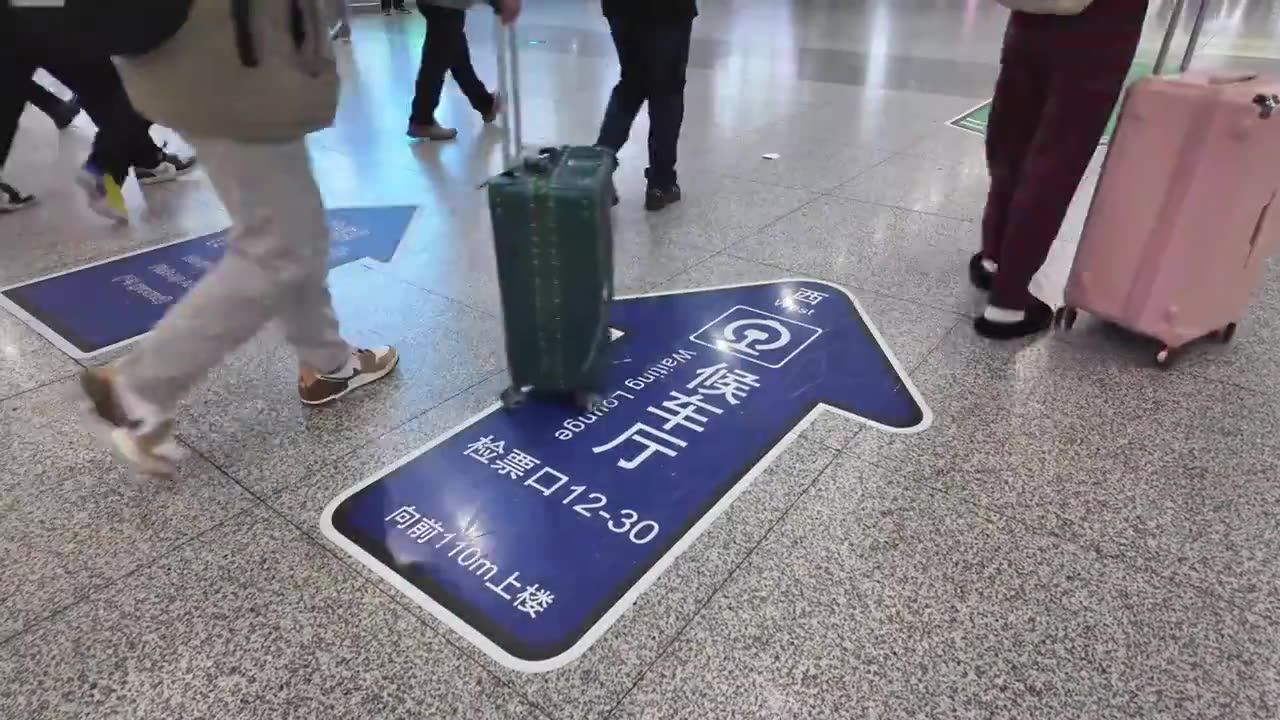 拖着行李箱的旅客走向火车站候车厅视频下载