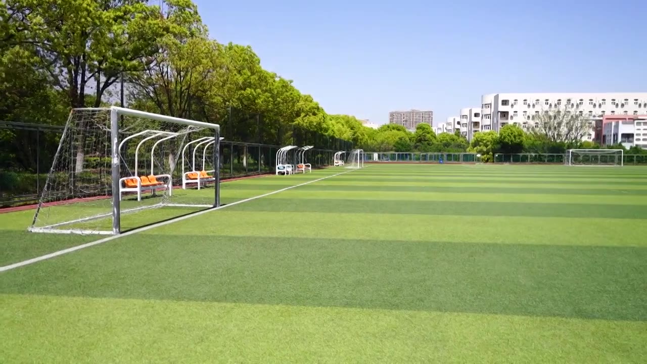 晴朗天气大学校园里露天人造草坪足球场的景观视频下载