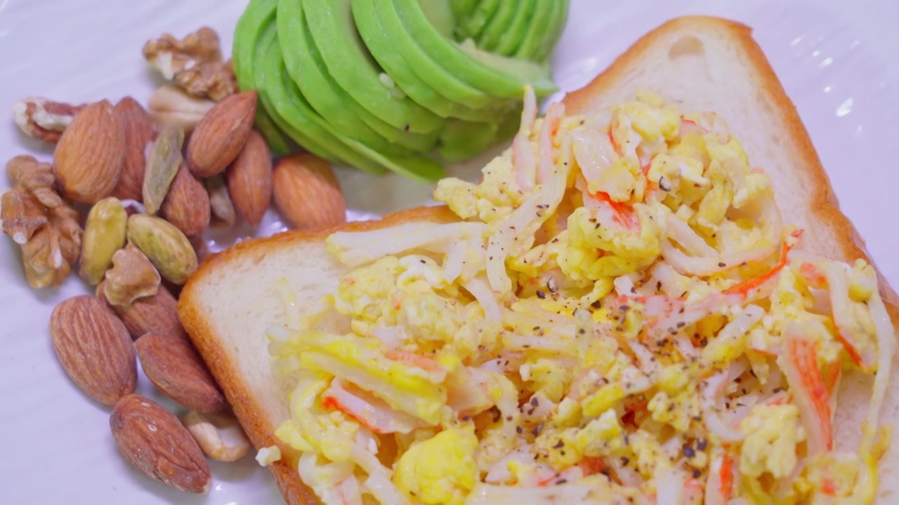 西式营养早餐牛油果坚果蟹柳滑蛋吐司面包片视频下载