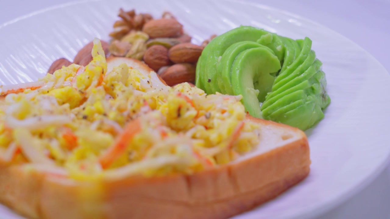 西式营养早餐牛油果坚果蟹柳滑蛋吐司面包片视频下载
