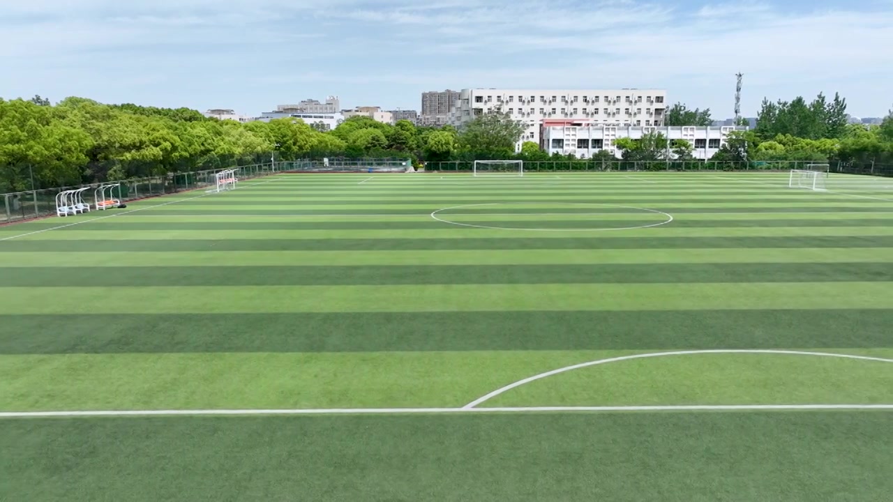 晴朗天气大学校园里露天人造草坪足球场景观设计视频下载