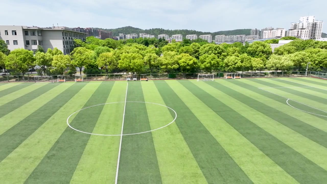 晴朗天气大学校园里露天人造草坪足球场景观设计视频下载