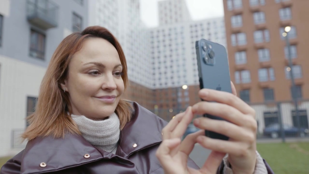 2020年11月，俄罗斯莫斯科:美女拿起iPhone。行动。女人视频下载