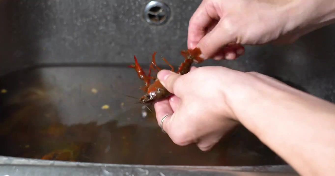 亚洲年轻男子清洗小龙虾去虾线特写镜头，从活蹦乱跳到盘中餐视频下载