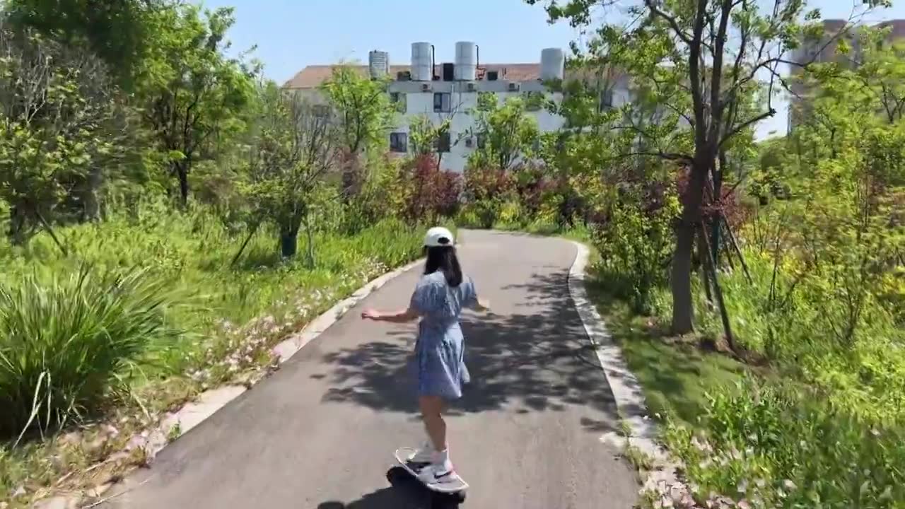 一名戴着帽子的年轻美少女在公园独自一人练习滑板动作,健康运动视频下载
