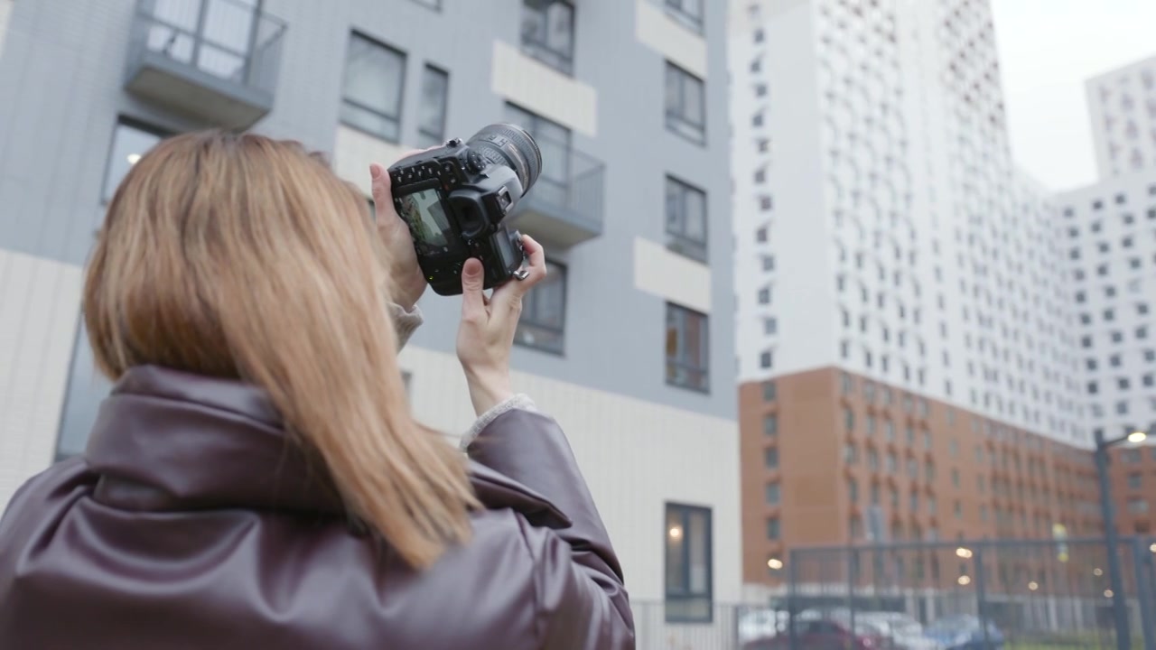 一名女子用专业相机拍摄建筑物。行动。美丽的视频下载
