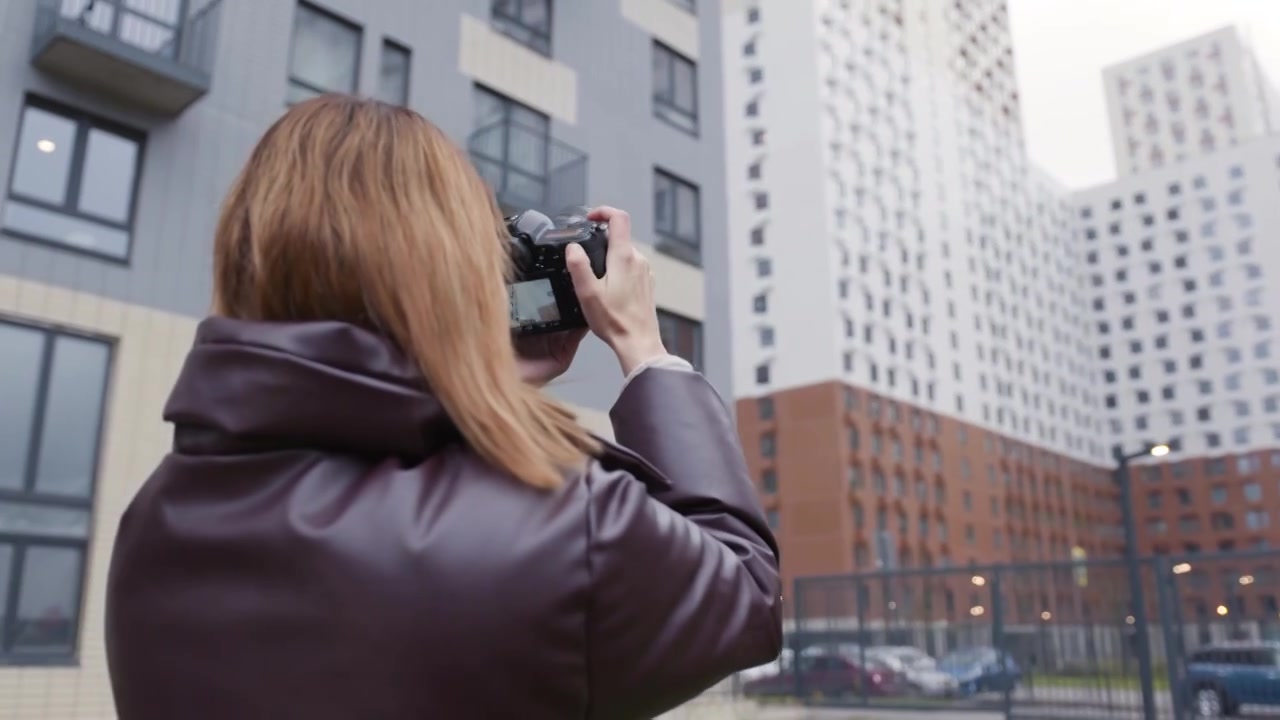 一名女子用专业相机拍摄建筑物。行动。美丽的视频下载