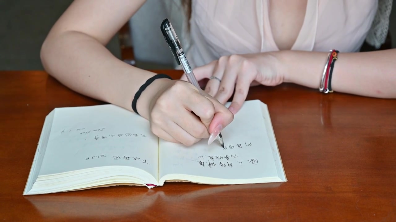 一位中国温柔美女女士坐在窗前用笔书写日记视频下载